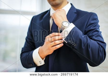 Close-up Of Man In Suit With Watch On His Hand Fixing His Cufflink. Groom Bow Tie Cufflinks
