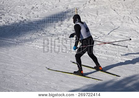 A Man In Dark Clothes, Goes Into The Distance Along The Path In The Snow, On A Winter Day