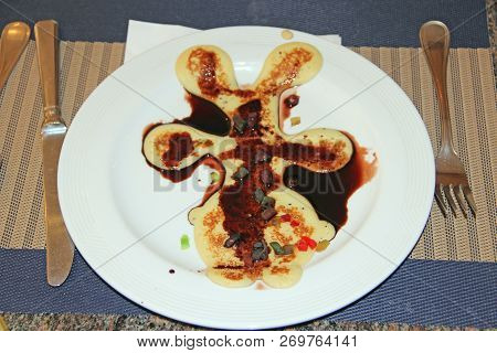 Pancake In Form Of Little Man Poured Chocolate In Restaurant. Haute Cuisine