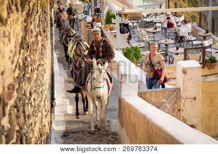 Thira, Santorini - 18.10.2018: Man On Traditional Donkey On Stairs In Thira, Santorini Island In Gre