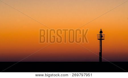 Abstract Photo Of A Light Signal Or Light Buoy Against A Brightly Colored Sky With Beautiful Intense