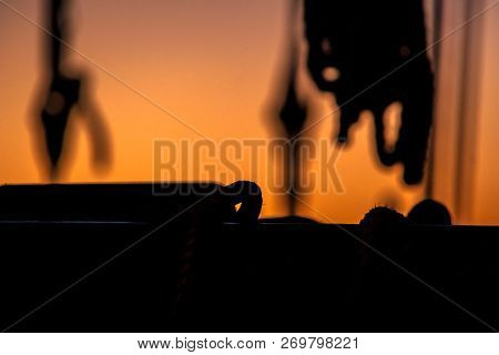 Ropes, Nets, Cables, Pulleys And Bollards As Shadows Against A Colorful Sky Of Red And Blue Colors O