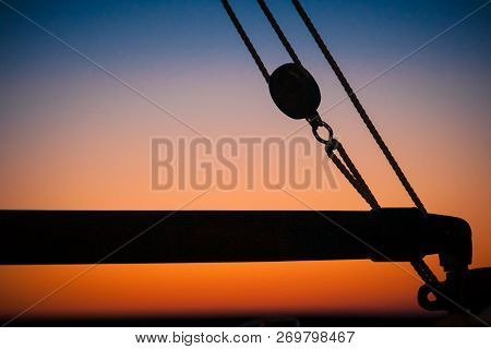 Ropes, Nets, Cables, Pulleys And Bollards As Shadows Against A Colorful Sky Of Red And Blue Colors O