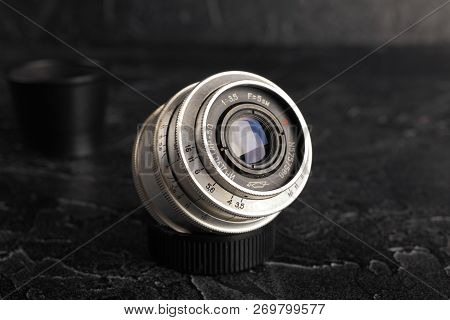 Moscow, Russia, December 14, 2017.vintage Lenses Industar-50, 50mm F 3, 5 On A Dark Concrete Backgro