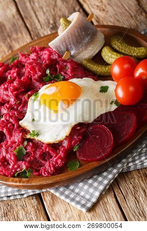 Labskaus Is A Traditional Northern Dish Of Potatoes, Corned Beef And Beets With Fried Egg, Pickles A