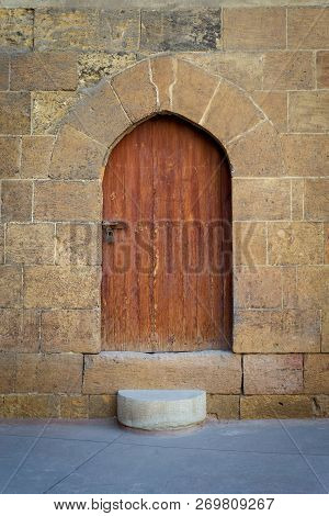 Old Wooden Door And Window Framed By Arched Bricks Stone Wall At The Courtyard Of Al Razzaz Historic