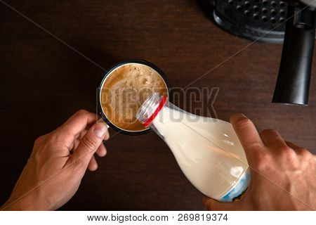 Photo Of Coffee Maker, Mans Hands Pouring Milk Into Mug Of Coffee In Kitchen