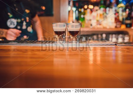 Bartender Making Shots On Black Bar With Reflection.