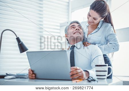 Openly Smiling Female Making Massage For Her Coworker