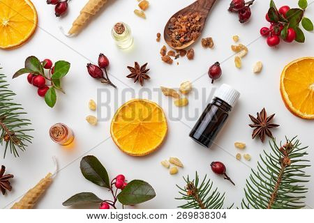 Bottles Of Essential Oil On A White Christmas Background With Frankincense, Myrrh, Wintergreen And V
