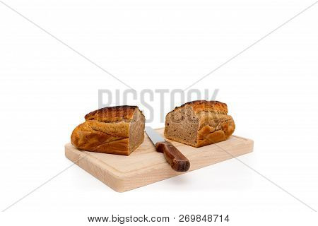 A Homemade Plumcake Standing On A Wooden Board With A White Background