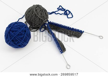 Knitting Needles With Knitting , Gray And Blue Balls Of Wool On White Background