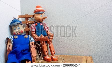 Two Pinocchio Puppet Made From Wood On Wood Box