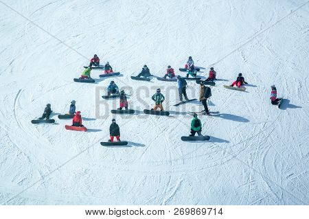 Lots Of Skiers And Snowboarders Have A Rest On A Slope At Ski Resort