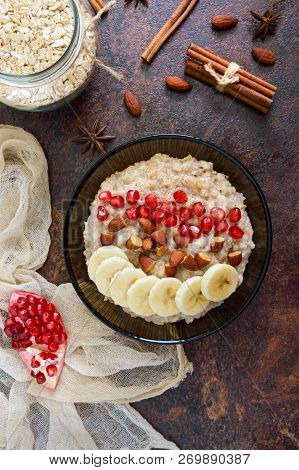 Delicious And Healthy Oatmeal With Banana, Pomegranate Seeds, Almond And Cinnamon. Healthy Breakfast