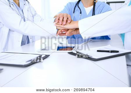 Group Of Doctors Joining Hands At Meeting. Teamwork And Success In Medicine