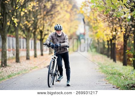 Active Senior Man With Electrobike Standing Outdoors On A Road In Nature.
