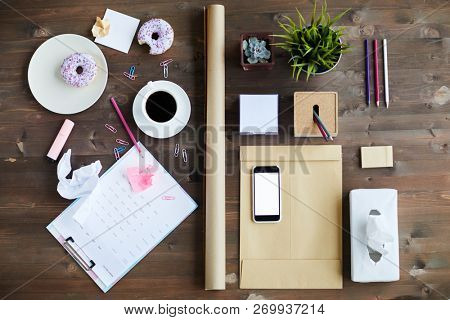 Fast food, cup of black coffee and various stuff for work of archtect or economist on wooden background