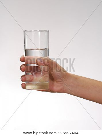 En youg kvinde hånd, der holder et glas vand.