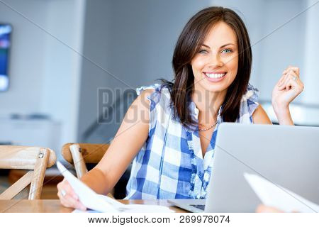 Woman with papers in their living room