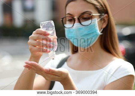 Close Up Of Girl With Medical Mask Using Hand Sanitizer Gel In City Street. Antiseptic, Hygiene And 