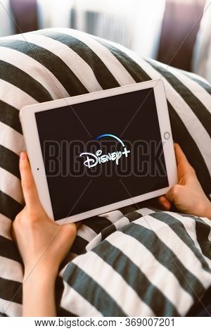 Girl Holding A Tablet With Disney Plus Logo On The Screen. High Quality Photo.