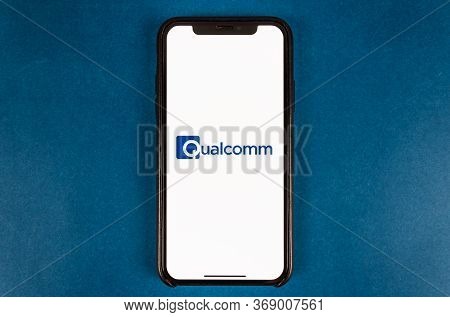 Hand Holds Smartphone With Qualcomm Logo. High Quality Photo.