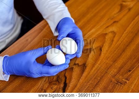 Close-up Of A Hand In Medical Nitrile Gloves.two White Chicken Eggs In The Hands.cooking In The Kitc
