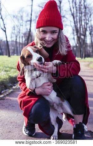 Pretty Young Girl In Redd Coat Playing With Dog Outside In Green Park, Lifestyle People Concept