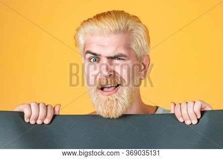 Young Man Shows A Sheet Of Paper In The Camera On A Color Background. Booklet Design Sheet Display R