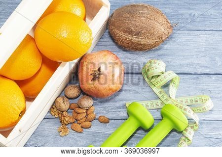 Lots Of Oranges, Dumbbells, Measuring Tape On A Wooden Textured Background. Fitness, Sports Nutritio