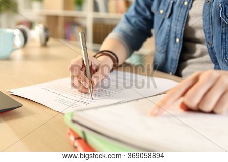 Close Up Of Student Girl Hand Doing Exam Checking Notebook Sitting On A Desk At Home