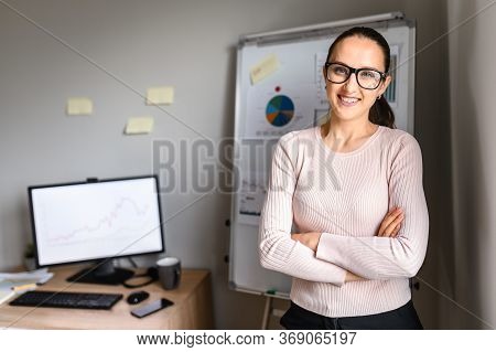 Horizontal Middle Shot Of A Female Employee With Hands Crossed Around Her Waist At The Office And Lo