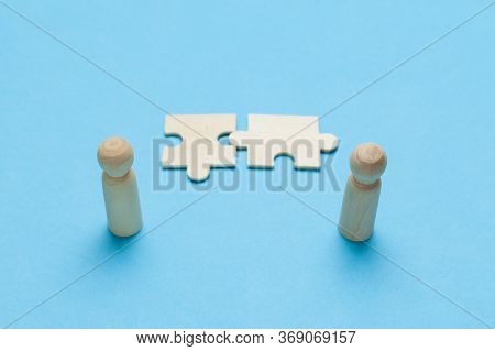 Wooden Figures With Pazzles On Blue Background. Agreement Between Business Mans, Cooperation And Dea