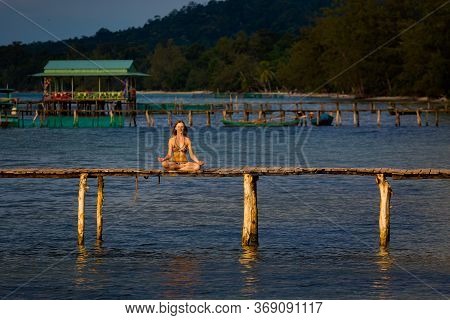 Young Woman Meditating In Tropical Vietnam