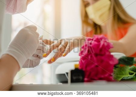 Woman with face mask during manicure in nail salon