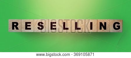 Resselling Word Wooden Cubes On The Green Background. Business Model Concept