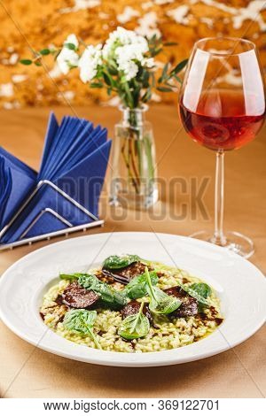 Risotto With Spinach And Chicken Liver Garnished With Spinach Leaves And Parmesan Cheese. Restaurant