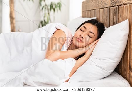 Peaceful Asian Girl Sleeping Resting Lying In Comfortable Bed In Bedroom At Home. Healthy Sleep Conc