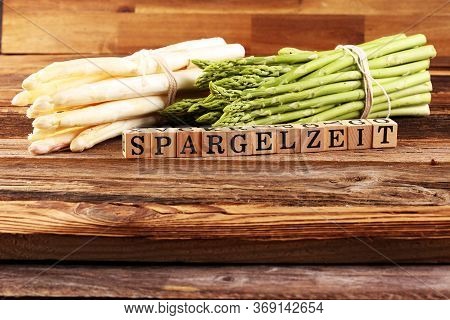 White And Green Asparagus On Background With The German Word Spargelzeit In Wooden Letter.