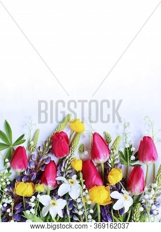 Bright Spring Flower Arrangement. Lilac Lupines, Crimson Tulips, White Daffodils, And Yellow Flowers