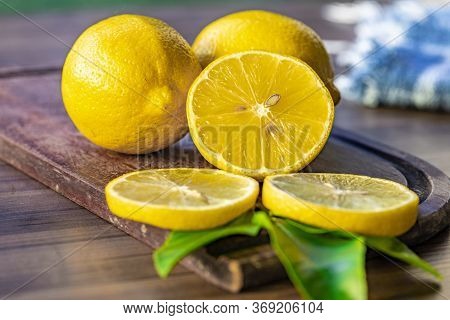 Top View Of Lemon And Green Leaves On Wooden Background