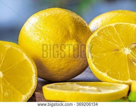 Top view of lemon and green leaves on wooden background