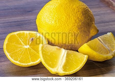 Top view of lemon and green leaves on wooden background