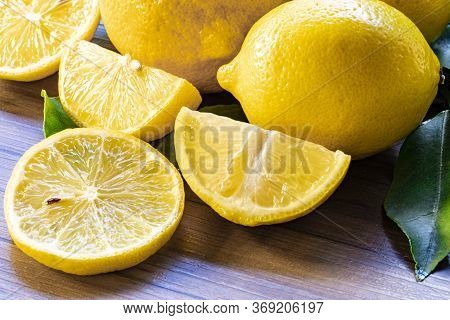 Top View Of Lemon And Green Leaves On Wooden Background