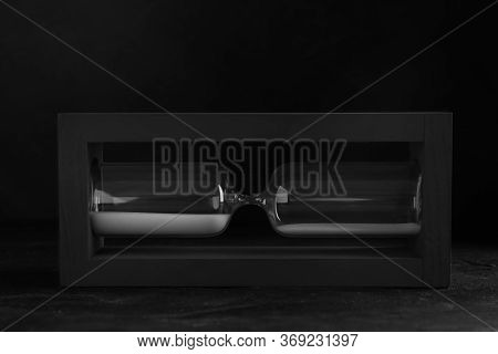Sandglass On Table Against Black Background. Pareto Principle Concept
