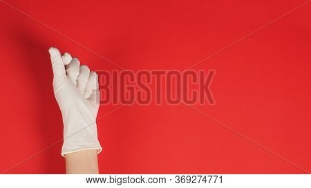 Mini Haert  Hand Sign With Gloves In Right Hand On Red Background.