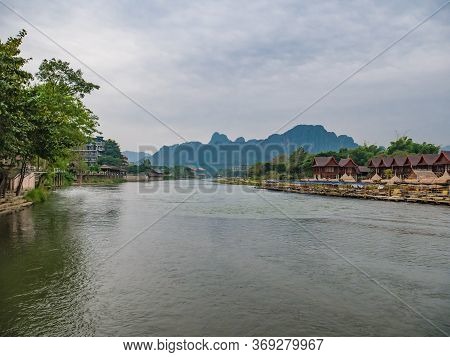 Beautiful View Of Nam Song River With Riverside Restaurant And The Mountain At Vangvieng City Lao.va