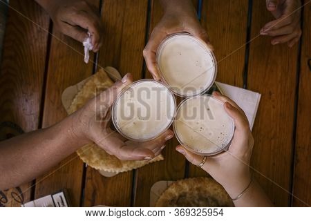 Three Of Happy Friends Drinking Beer And Toasting Beer. Friendship Concept With Young People Having 