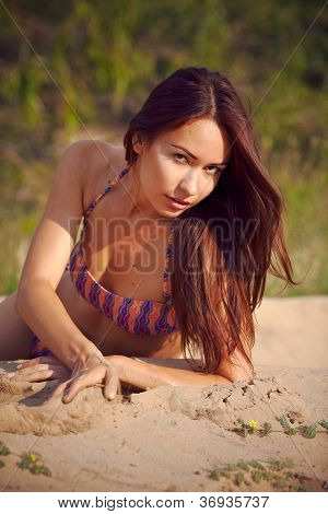 Smuk pige i en bikini på en baggrund en fyrreskov.